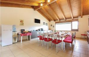 kuchnia z jadalnią ze stołami i czerwonymi krzesłami w obiekcie Villa Rossana w mieście Marano Marchesato
