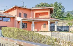 une maison rose avec une clôture devant elle dans l'établissement Villa Rossana, à Marano Marchesato