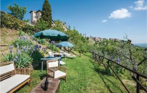 un jardin avec des chaises et des parasols sur une colline dans l'établissement Zafferano 3, à San Gimignano