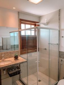 a bathroom with a glass shower and a sink at Casa Reserva Praia do Forte 2 quartos Conforto e Charme in Praia do Forte