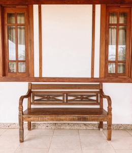 a wooden bench sitting in front of a wall at Casa Reserva Praia do Forte 2 quartos Conforto e Charme in Praia do Forte