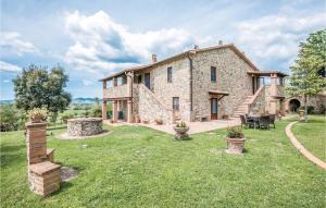una gran casa de piedra con un patio de césped en Cortilla 2, en Cinigiano