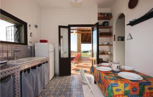 una cucina con tavolo e piatti di Amazing Home In San Vito Lo Capo -tp- With Kitchen a San Vito lo Capo