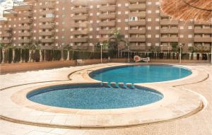 a swimming pool in front of a large building at Cozy Apartment In Oropesa Del Mar in Oropesa del Mar