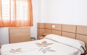 a small bedroom with two beds and a dresser at Cozy Apartment In Oropesa Del Mar in Oropesa del Mar