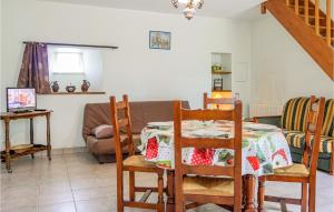 een eetkamer met een tafel en een bank bij 1 Bedroom Gorgeous Home In Digosville in Digosville
