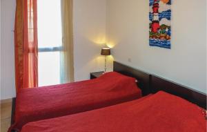 a bedroom with two beds with red sheets and a window at Amazing Apartment In Collioure in Collioure