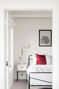una camera bianca con un letto con un cuscino rosso di A Modern Point of View - Luxe Loft - Espadin LoHi a Denver