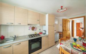 a kitchen with wooden cabinets and a table with a tableablish at Casa Bouganville in Magomadas