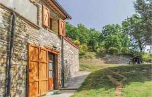a stone building with a wooden door next to a yard at Agriturismo La Ginestra in Lama