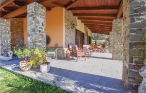 an outdoor patio with chairs and a stone building at Villa Aquaro in Ogliastro Cilento