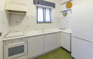 a kitchen with white cabinets and a sink at Villa Antica in Stalettì