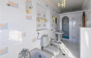 a white bathroom with a toilet and a sink at Villa Antica in Stalettì