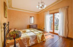 a bedroom with a bed and a large window at Stunning Home In Saline Ioniche in Saline Joniche
