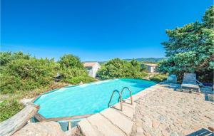 a swimming pool with two chairs next to it at Ginepri Bilo in Badesi