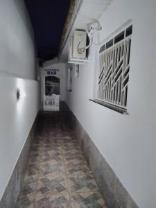 um corredor com paredes brancas e piso em azulejo em HOTEL LATINOS 2 em Boa Vista