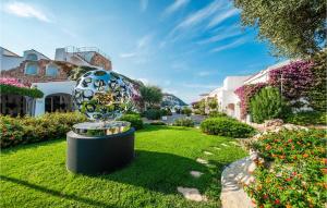 a sculpture in a yard with flowers and buildings at Trilo 6 in Baja Sardinia