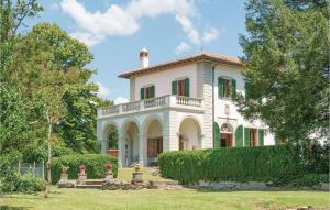 une maison blanche avec des volets verts et des arbres dans l'établissement Villa Di Casole, à Molezzano