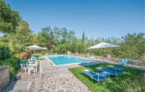 una piscina con sillas y sombrillas azules en Magnolia, en Lucolena in Chianti