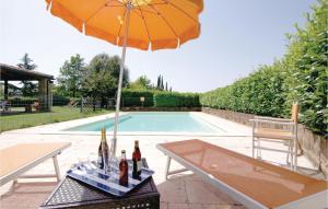 a table with bottles and an umbrella next to a pool at Lortale in Pitigliano