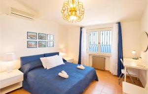 Un dormitorio con una cama azul y una lámpara de araña. en Lovely Home In Staletti With Kitchen, en Stalettì