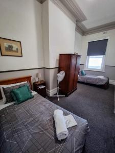 MillicentThe Grand Hotel Millicent的有两张床和一扇窗户的卧室