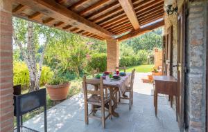 patio ze stołem i krzesłami pod drewnianym sufitem w obiekcie La Querciola w mieście Monte Castelli