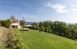 Monte CastelliにあるLa Querciolaの緑の芝生のある丘の上の家