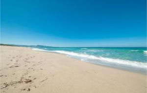 a beach with footprints in the sand and the ocean at Ginepri Bilo in Badesi