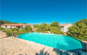 a swimming pool in front of a house at Ginepri Bilo in Badesi