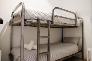 two bunk beds in a room with a ladder at Sagrada Familia Comfy apartment in Barcelona