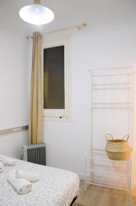 una camera con letto, finestra e cesto di Sagrada Familia Comfy apartment a Barcellona