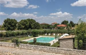 una piscina en un jardín con una pared de piedra en Villa Mara, en Ragusa