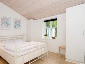 GlesborgにあるHoliday home Glesborg XLIVの白いベッドルーム(ベッド1台、窓付)