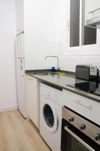 a kitchen with a washing machine and a sink at Sagrada Familia Comfy apartment in Barcelona