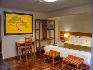 a hotel room with a bed and a table and chairs at Sol Ollantay Boutique Hotel in Ollantaytambo