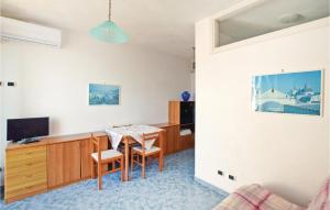 ein Wohnzimmer mit einem Tisch und einem TV in der Unterkunft Amazing Apartment In Santangelo Dischia With House Sea View in Ischia