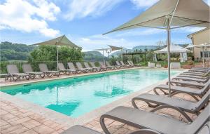 a swimming pool with lounge chairs and umbrellas at Flora House 2 in Macerino