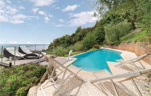 a swimming pool with two chairs next to the ocean at Casa Di Giulio in Massaciuccoli