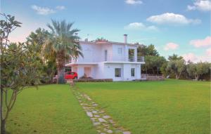 a white house with a palm tree and a yard at Caprice in Míloi