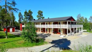 un gran edificio rojo y blanco con árboles en el fondo en Piteå Golfhotell, en Piteå