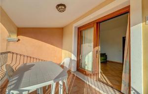 a balcony with a table and a glass door at Mono 2 in Badesi