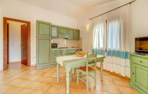 a kitchen with green cabinets and a table at Mono 2 in Badesi