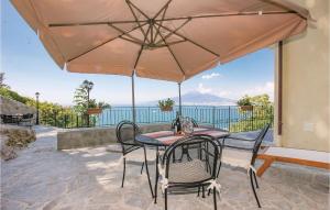 Un patio con una mesa y sillas y una sombrilla. en Casa Maria Elena, en Castellammare di Stabia
