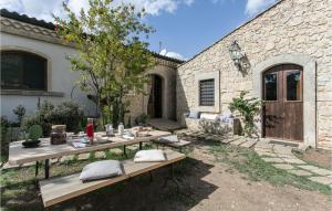 a patio with two wooden tables in front of a building at Tenuta Santa Lucia in Noto