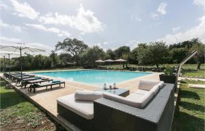 a swimming pool with couches and chairs next to a pool at Tenuta Santa Lucia in Noto