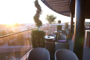 a balcony with chairs and tables and a view of a city at Orbis Design Hotel & Spa in Paraćin
