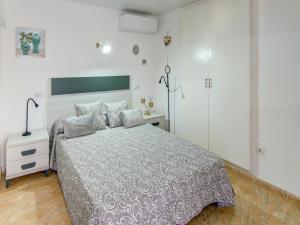 a bedroom with a large bed and a night stand at Belvilla by OYO Apartment in Lloret de Mar in Lloret de Mar