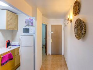 a kitchen with a white refrigerator and a hallway at Belvilla by OYO Apartment in Lloret de Mar in Lloret de Mar