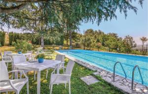 Montopoli in SabinaにあるAwesome Home In Montopoli Di Sabina Ri With Outdoor Swimming Poolのスイミングプールの横のテーブルと椅子
